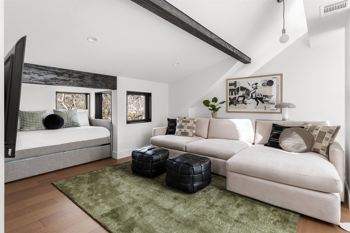 Spacious and versatile sleeping area featuring modern furnishings and plush seating—designed for comfort, relaxation, and flexibility for larger groups.