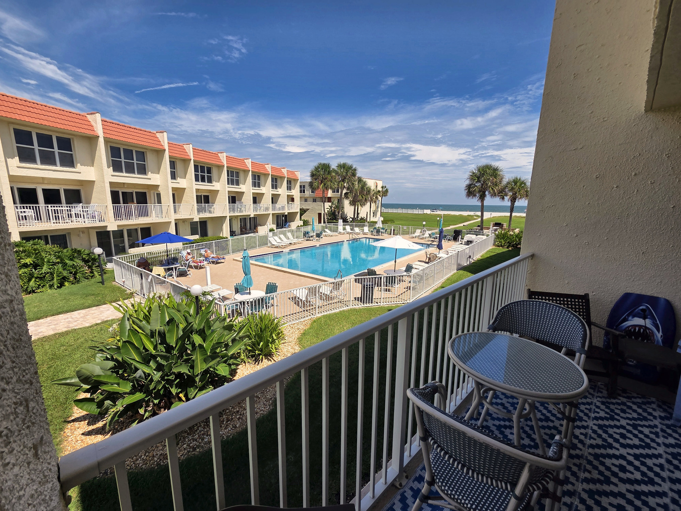 Private balcony overlooking the pool and ocean, perfect for morning coffee.