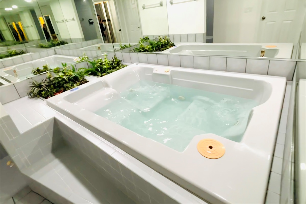 Large jacuzzi hot tub (optional use) in bathroom in Coastal Retreat Primary Suite 