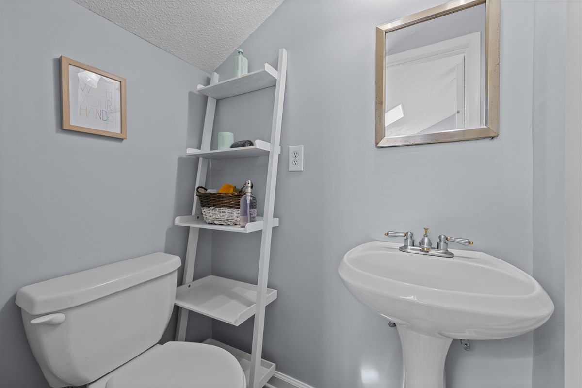 Loft ensuite bathroom with pedestal sink and simple, beachy touches for everyday comfort