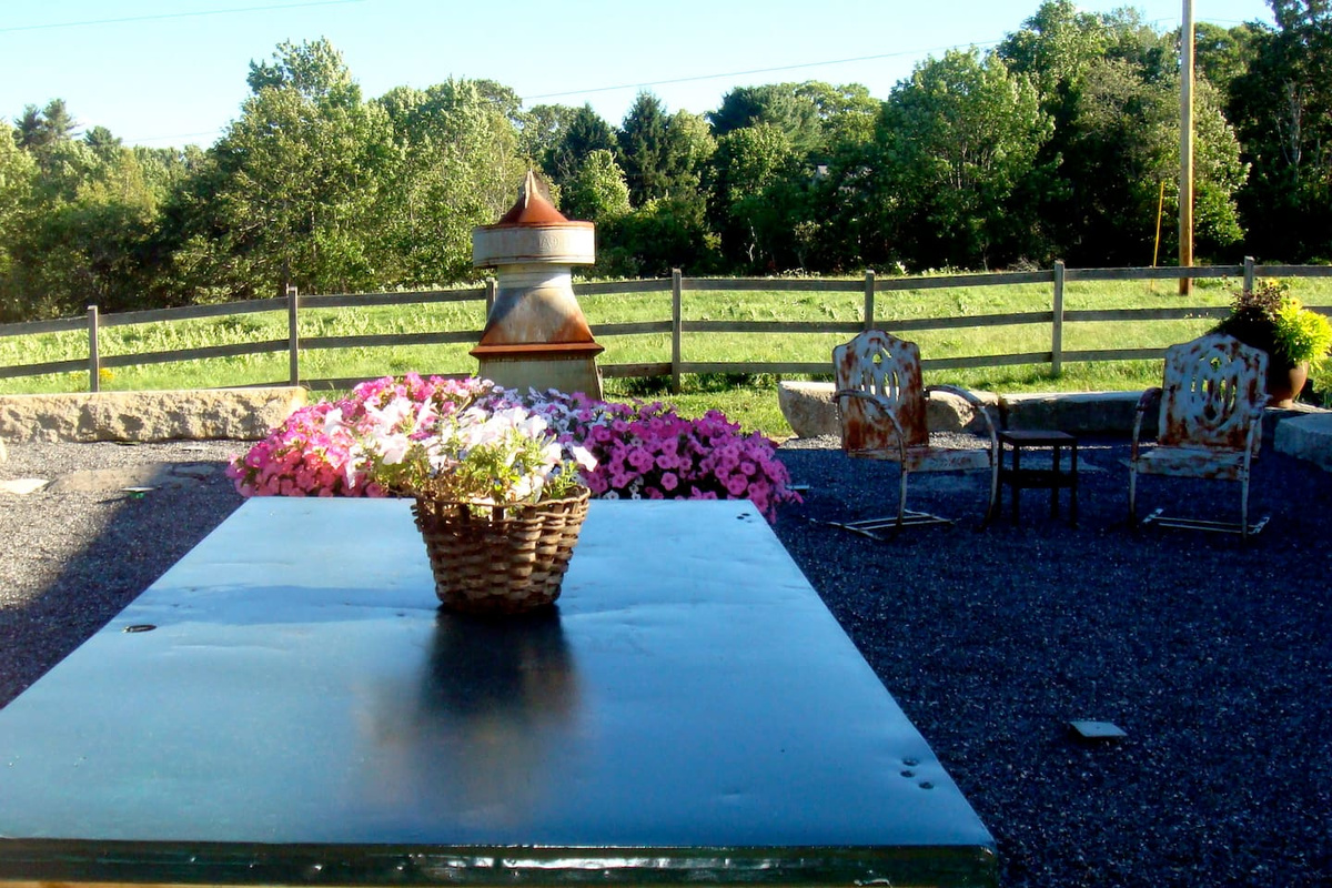 Outdoor terrace dining table with pastoral view. Seats 8 easily. Elevated outdoor fireplace immediately in front of the table provides light and heat on chilly evenings.