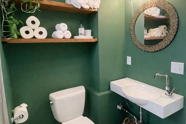 Stylish bathroom with green accent walls and contemporary design.