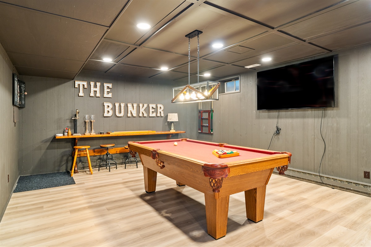 Step into “The Bunker” – a fully loaded game room with a pool table, flat-screen TV, and bar seating for the ultimate hangout spot.