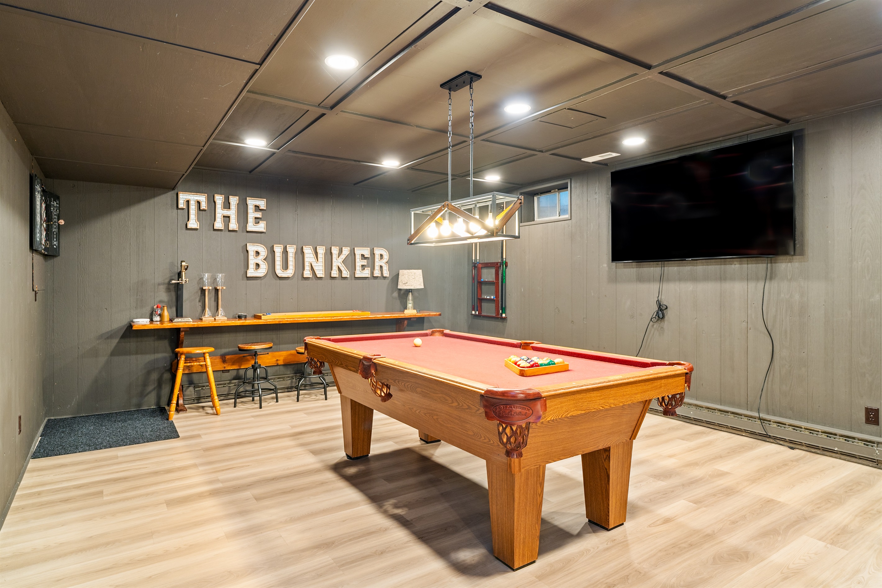 Step into “The Bunker” – a fully loaded game room with a pool table, flat-screen TV, and bar seating for the ultimate hangout spot.