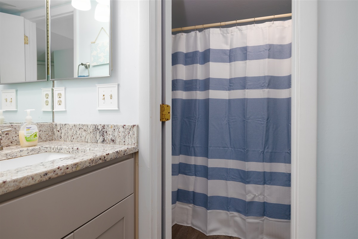 Bathroom 1 with a bright vanity and refreshing coastal-style shower