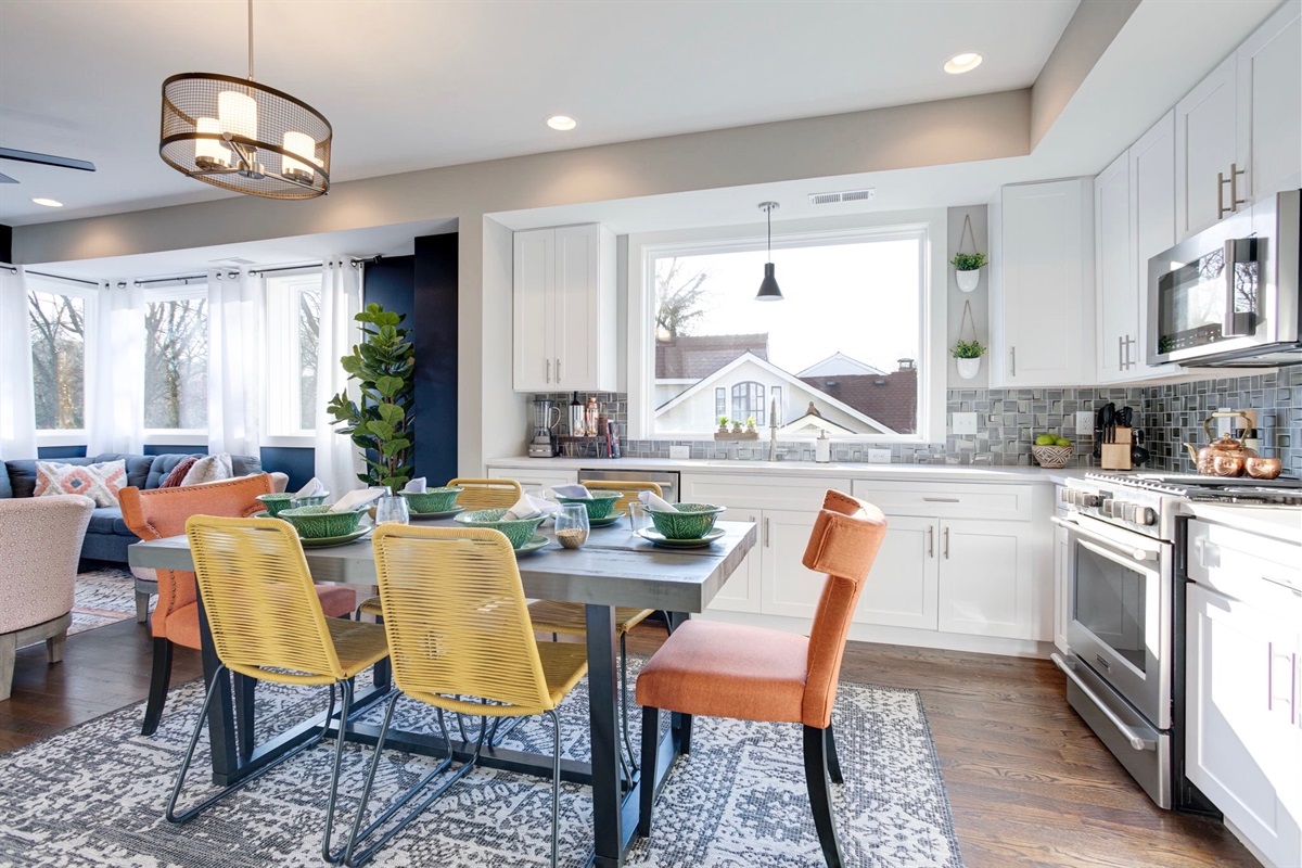 - Bright, modern kitchen with oversized window, stainless appliances & cheerful vibes - Gather around a bold dining table with eclectic chairs & playful textures - Perfect flow into the cozy living space, ideal for sharing meals & memories