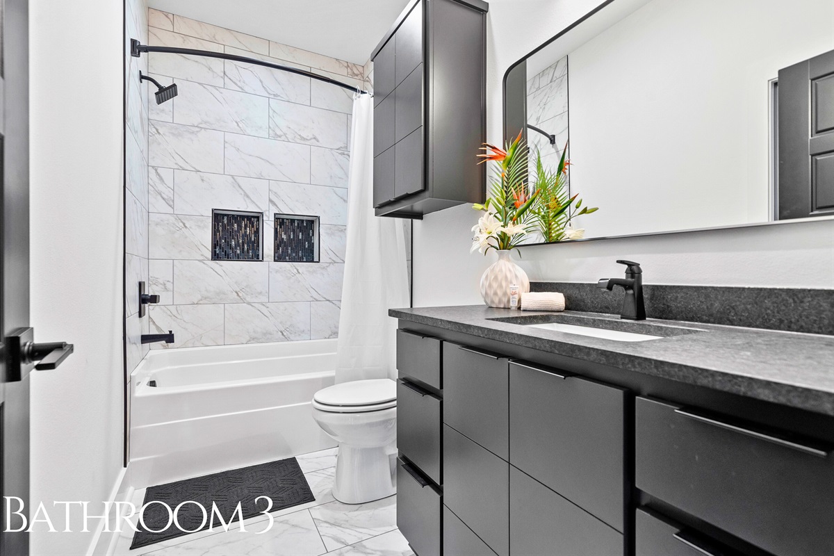 A sleek and calming bathroom with minimalist design and bright lighting, offering a refreshing and modern space to unwind.
