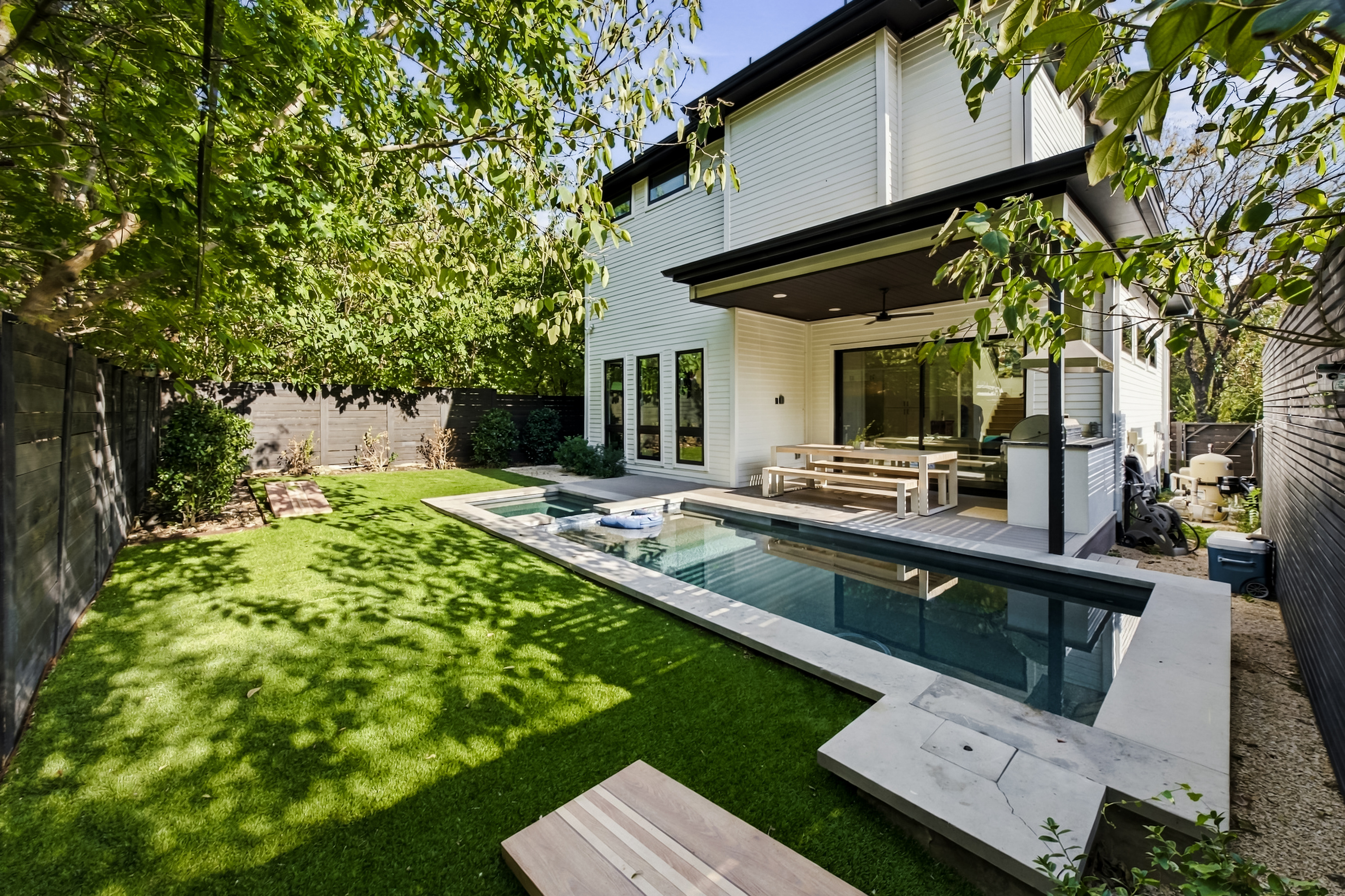 Covered patio overlooks the pool — the perfect spot to relax after a swim.