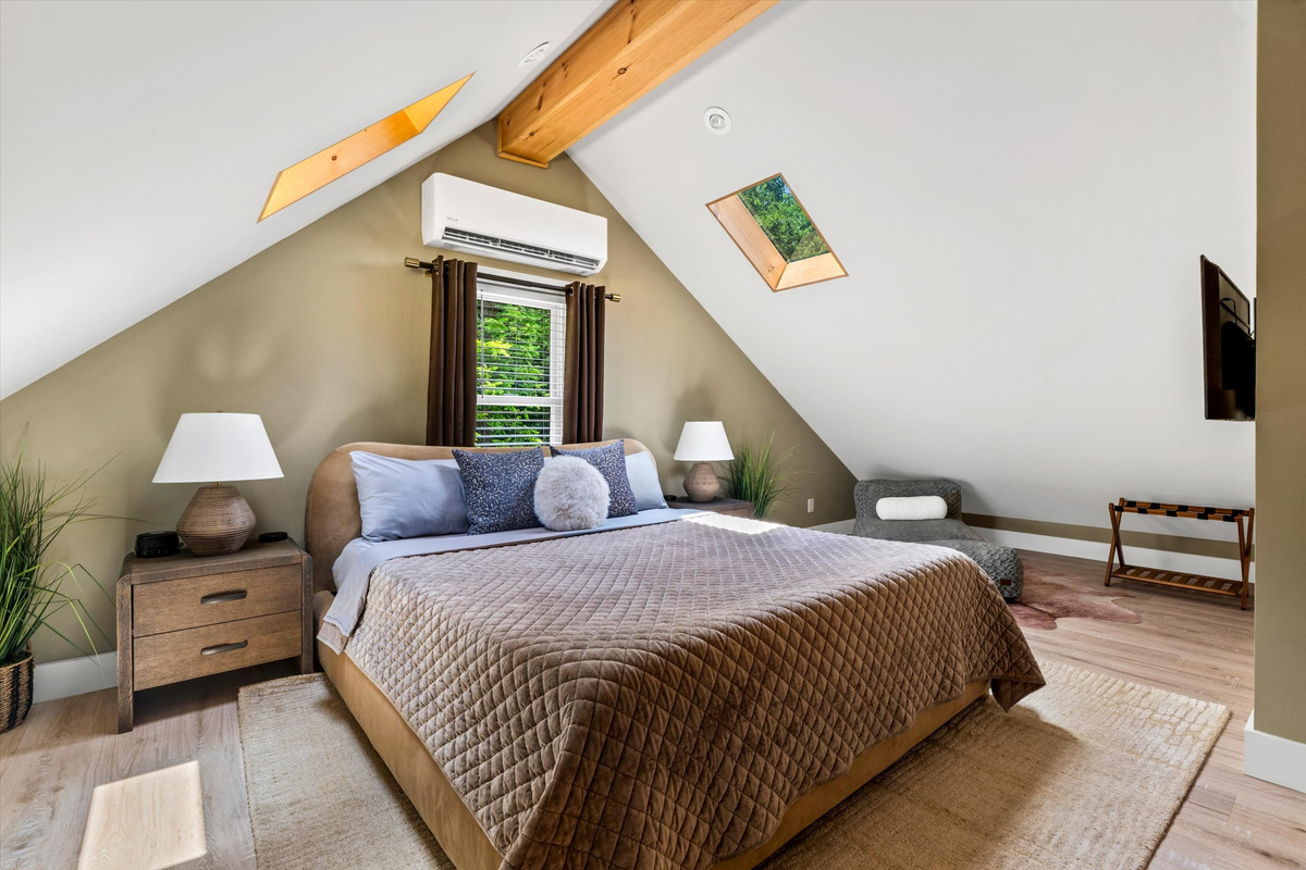 The Penthouse: Master Bedroom with King Bed, 42-inch Smart TV, Fireplace, sound machine, blackout curtains and cozy reading chair.