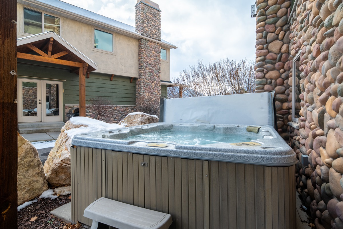 Hot tub area surrounded by stone exterior and privacy