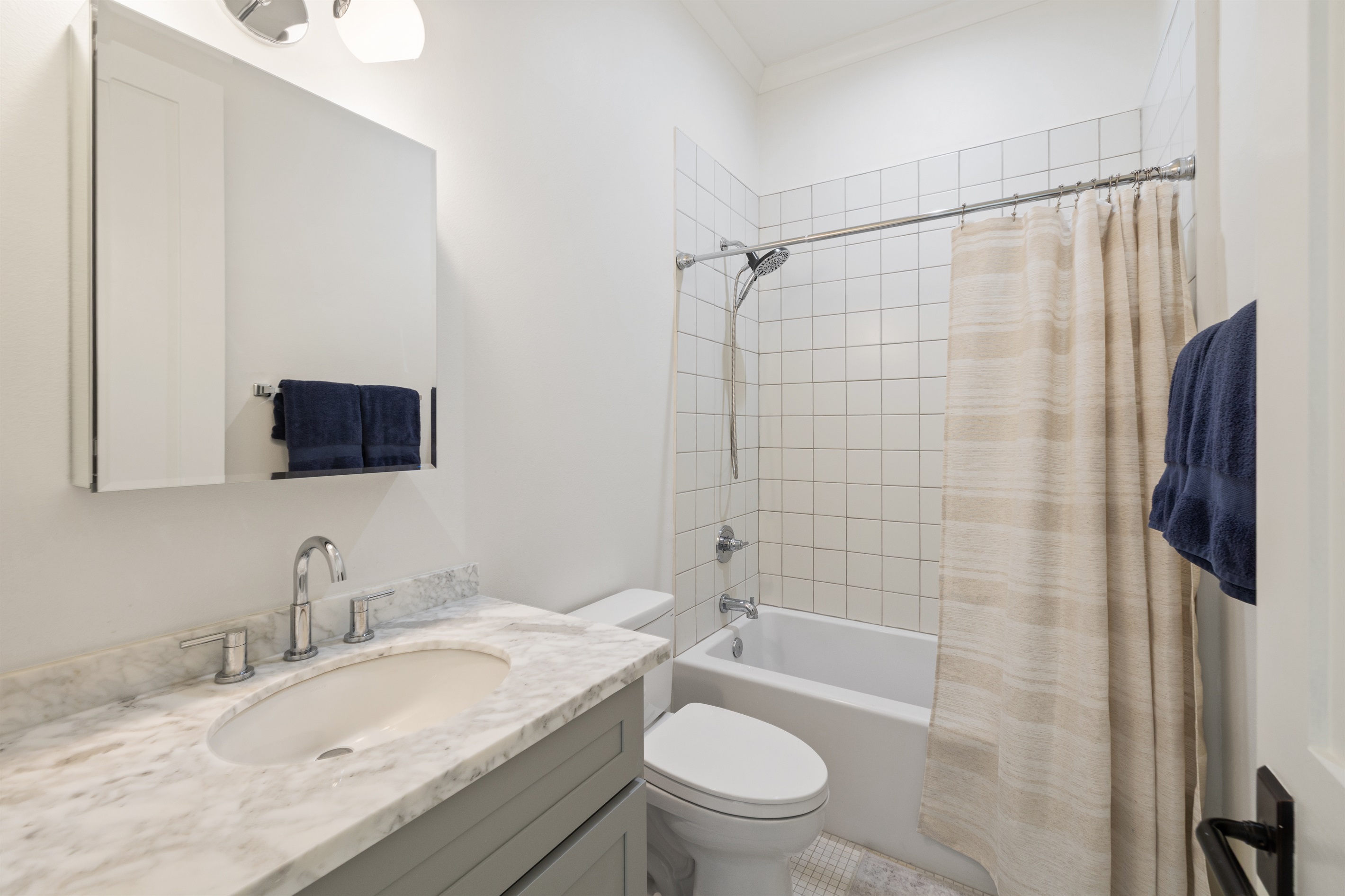 Calming bath with single vanity and tub-shower, designed for slow mornings and easy Gulf Coast living.