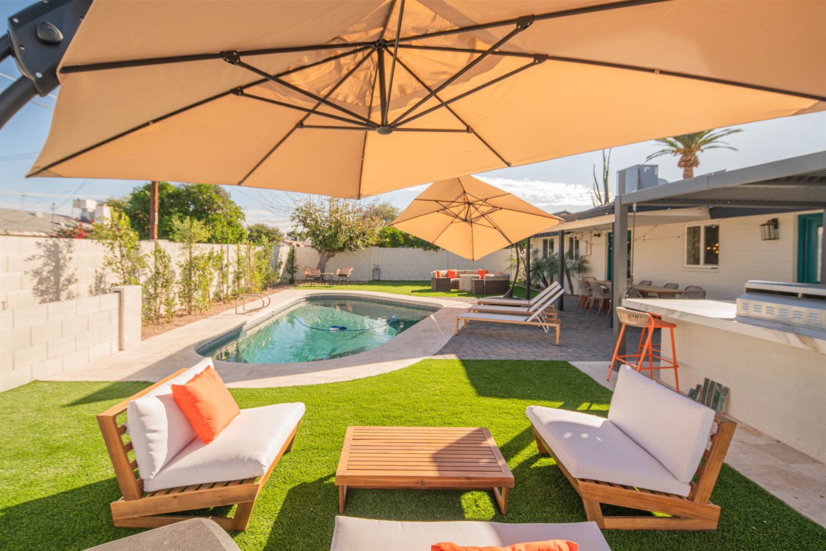 Relax outdoors in a private backyard featuring a sparkling pool, lounge seating, and shaded areas — perfect for sunny Scottsdale days and evenings.