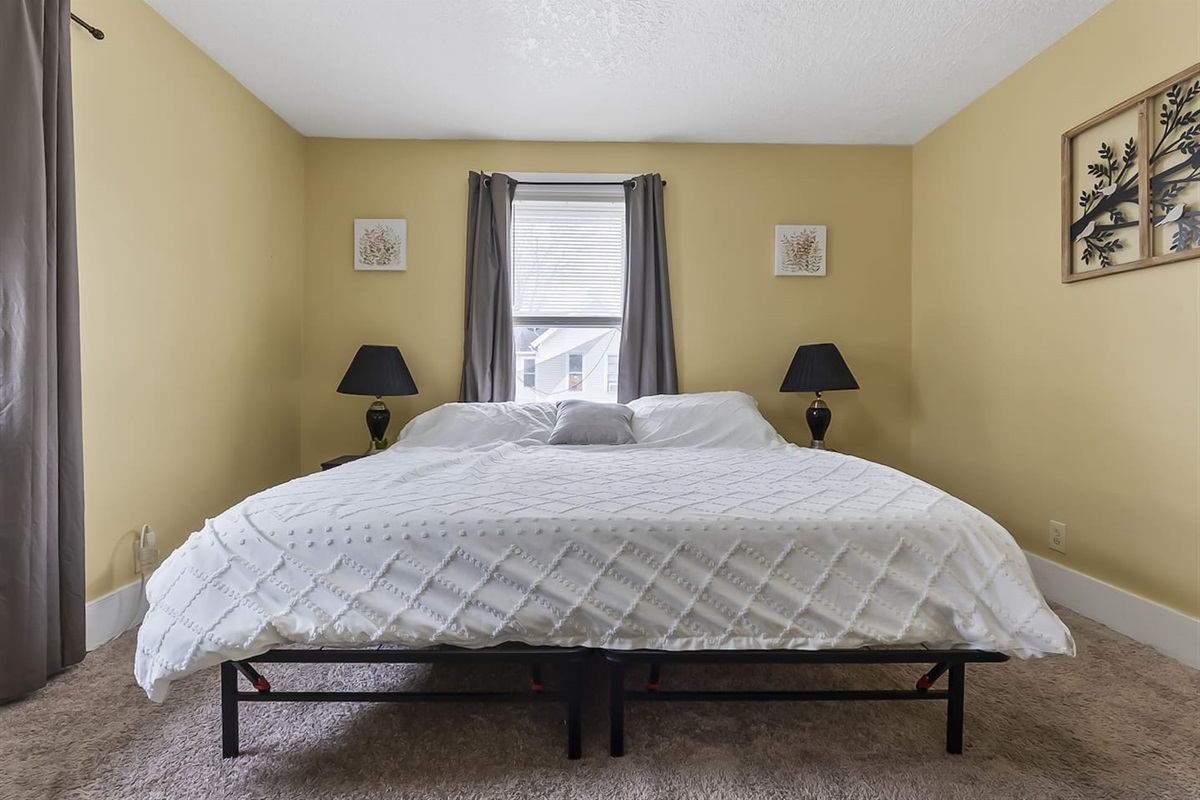 Spacious bedroom featuring a comfortable king-sized bed and large windows that fill the room with natural light.