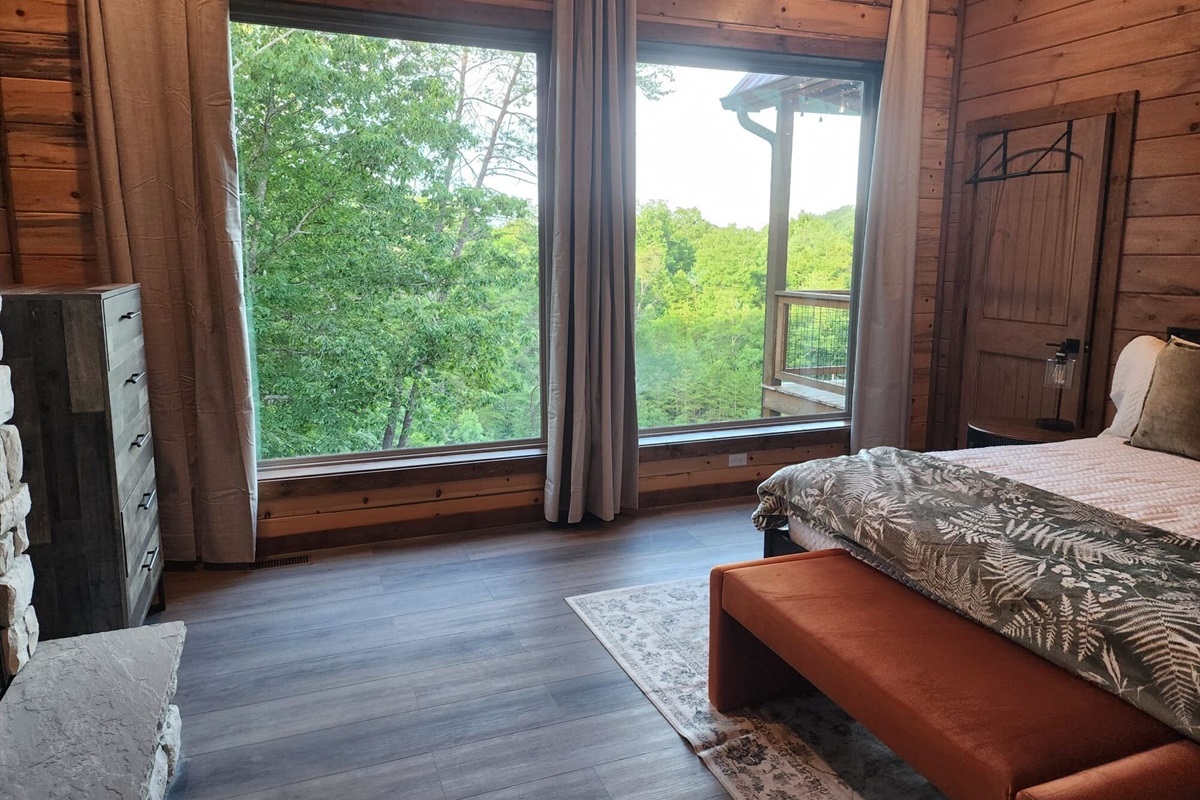 Bedroom with king bed, wood paneling, and cozy decor