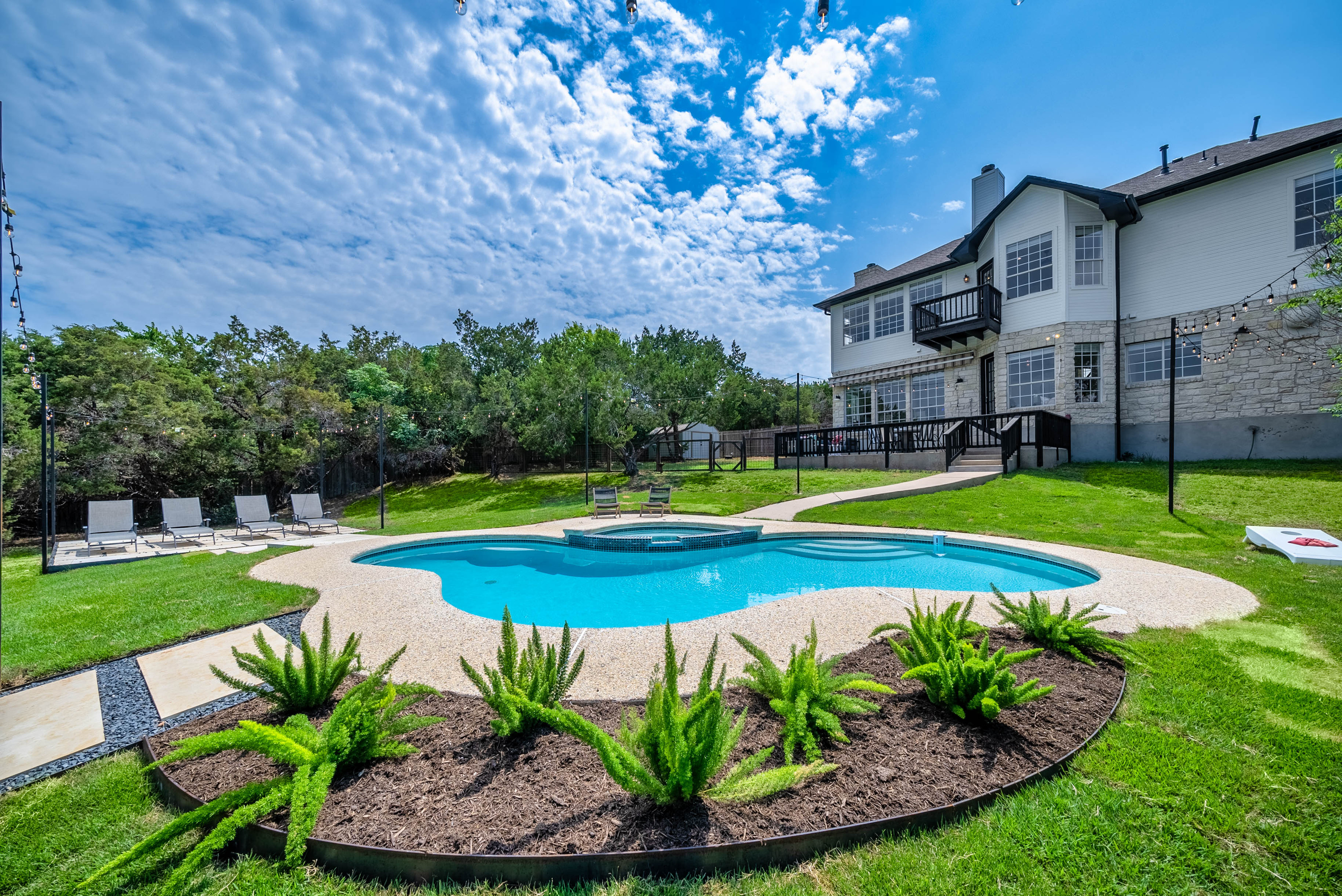 Freshly landscaped pool area offers a peaceful backyard escape.
