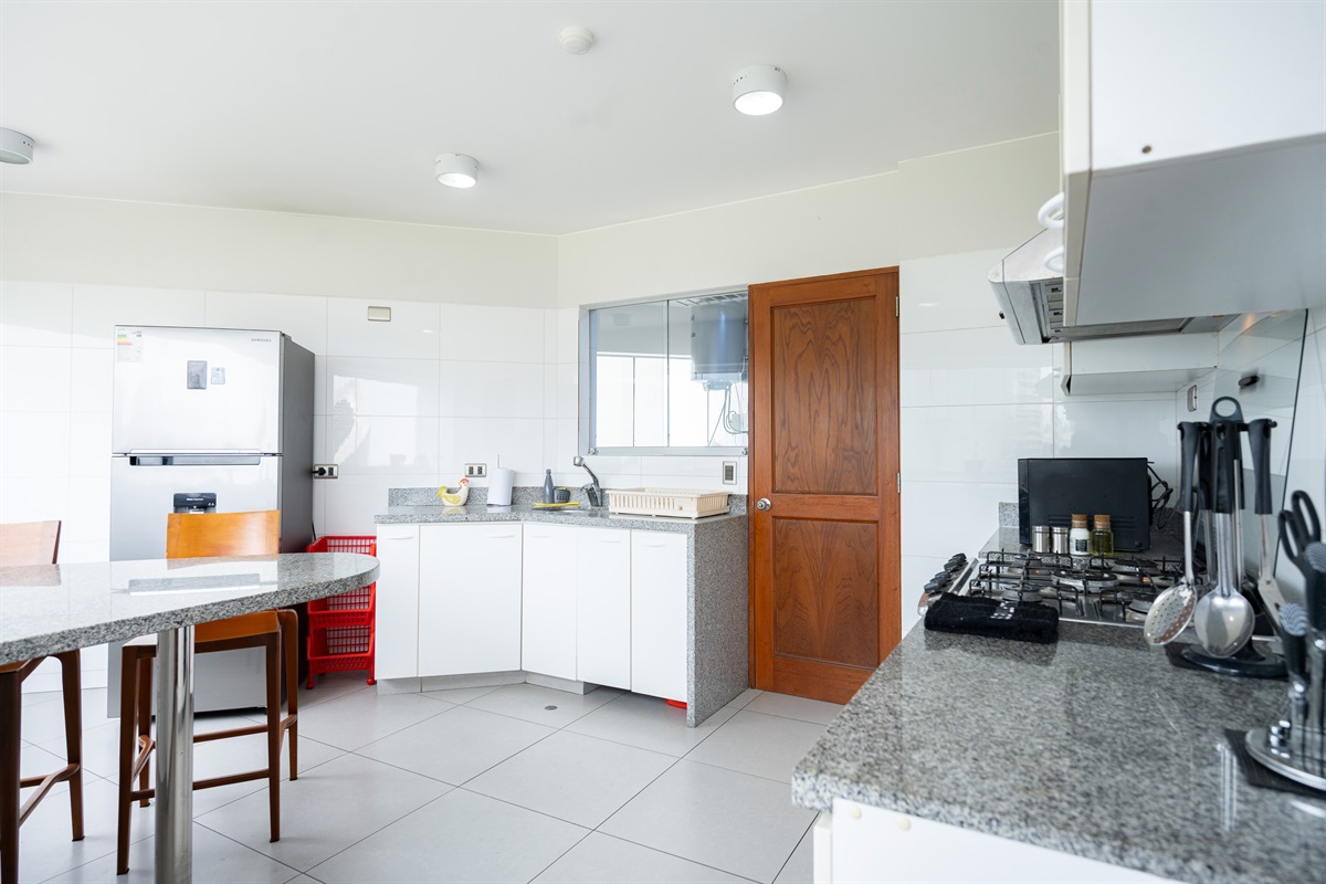 Fully equipped kitchen with electric stove, oven, large fridge, and everything you need to cook at home  /  Cocina totalmente equipada con estufa eléctrica, horno, refrigeradora grande y todo lo necesario para cocinar en casa