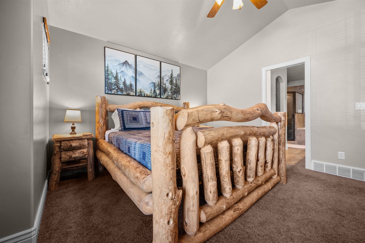 Rustic log bed and vaulted ceilings create a true mountain retreat.