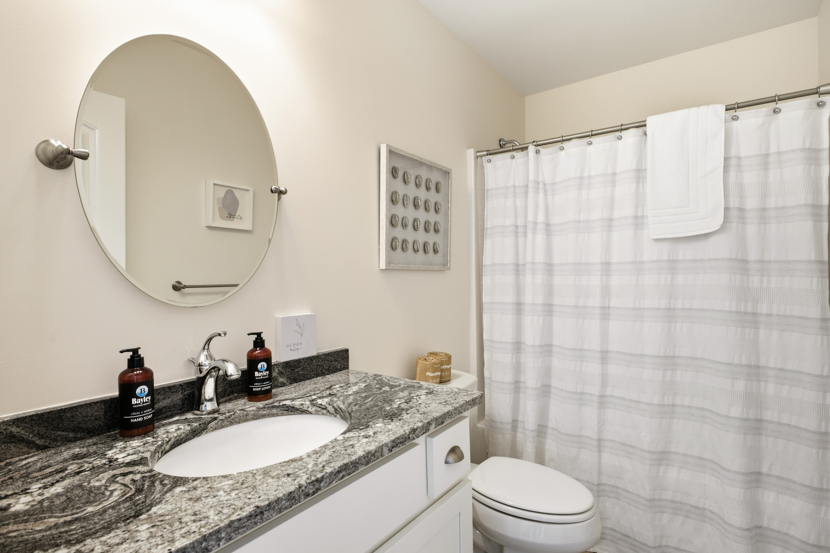 Clean, well-appointed full bathroom with a spacious vanity, large mirror, toilet, and shower/tub combination with fresh towels provided.