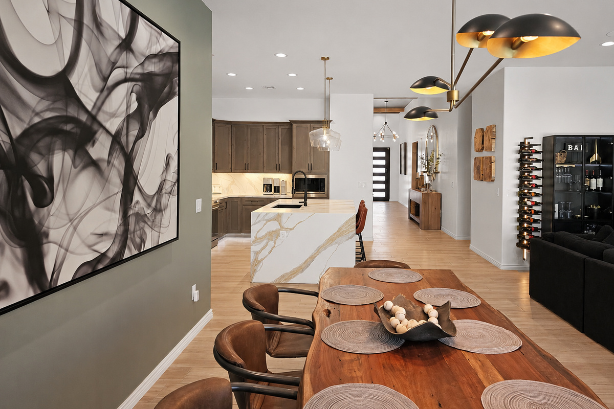 A dramatic Restoration Hardware light fixture hangs above the dining table, creating a sophisticated focal point.