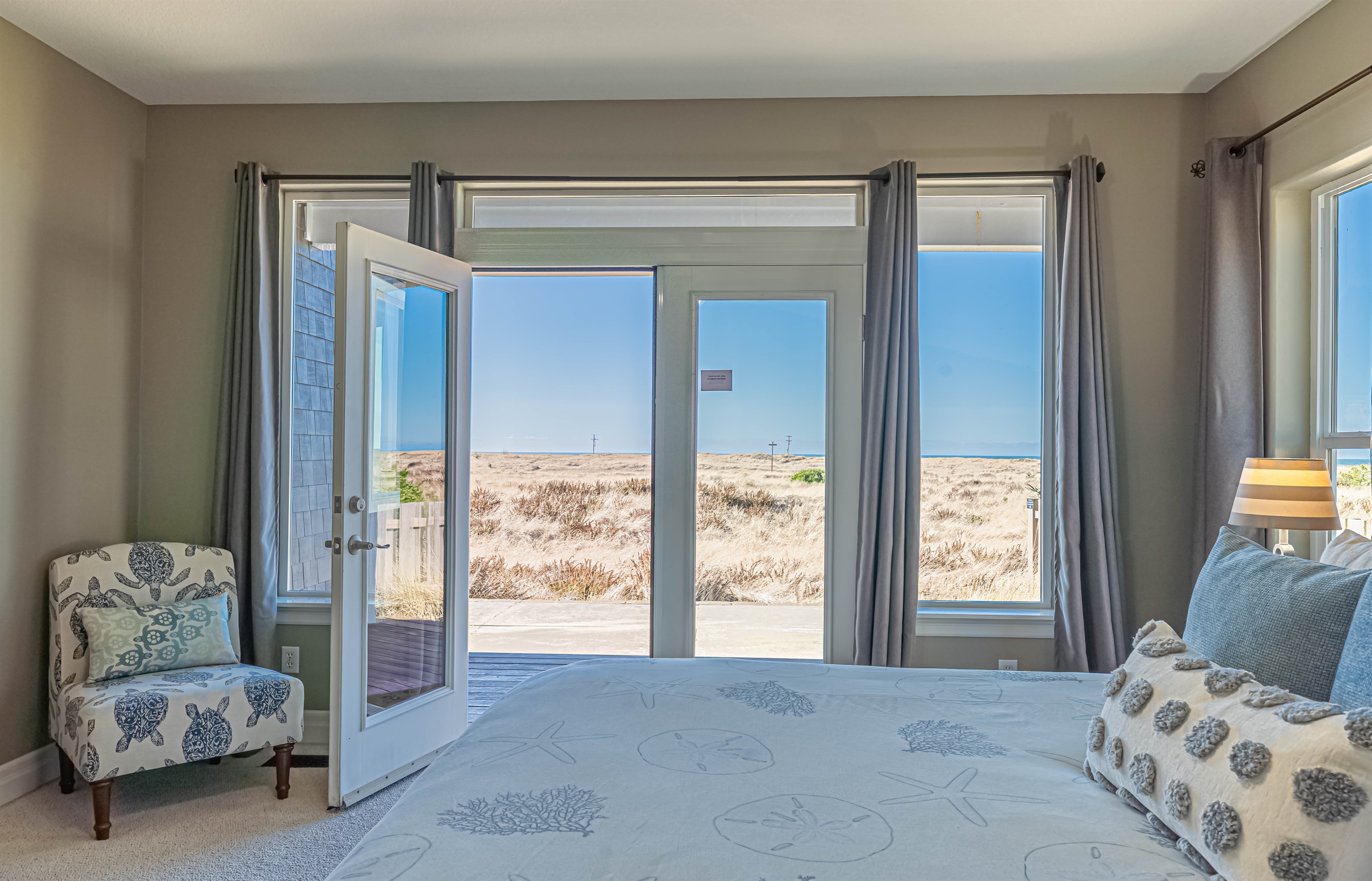 Primary bedroom on main floor has French doors leading out to private deck and gorgeous ocean views!!