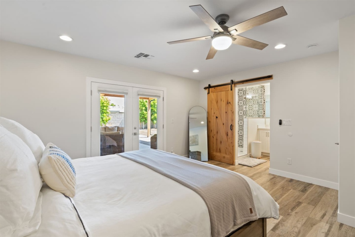 Main ensuite bedroom with queen bed, clean bedding, storage, and a simple restful layout.