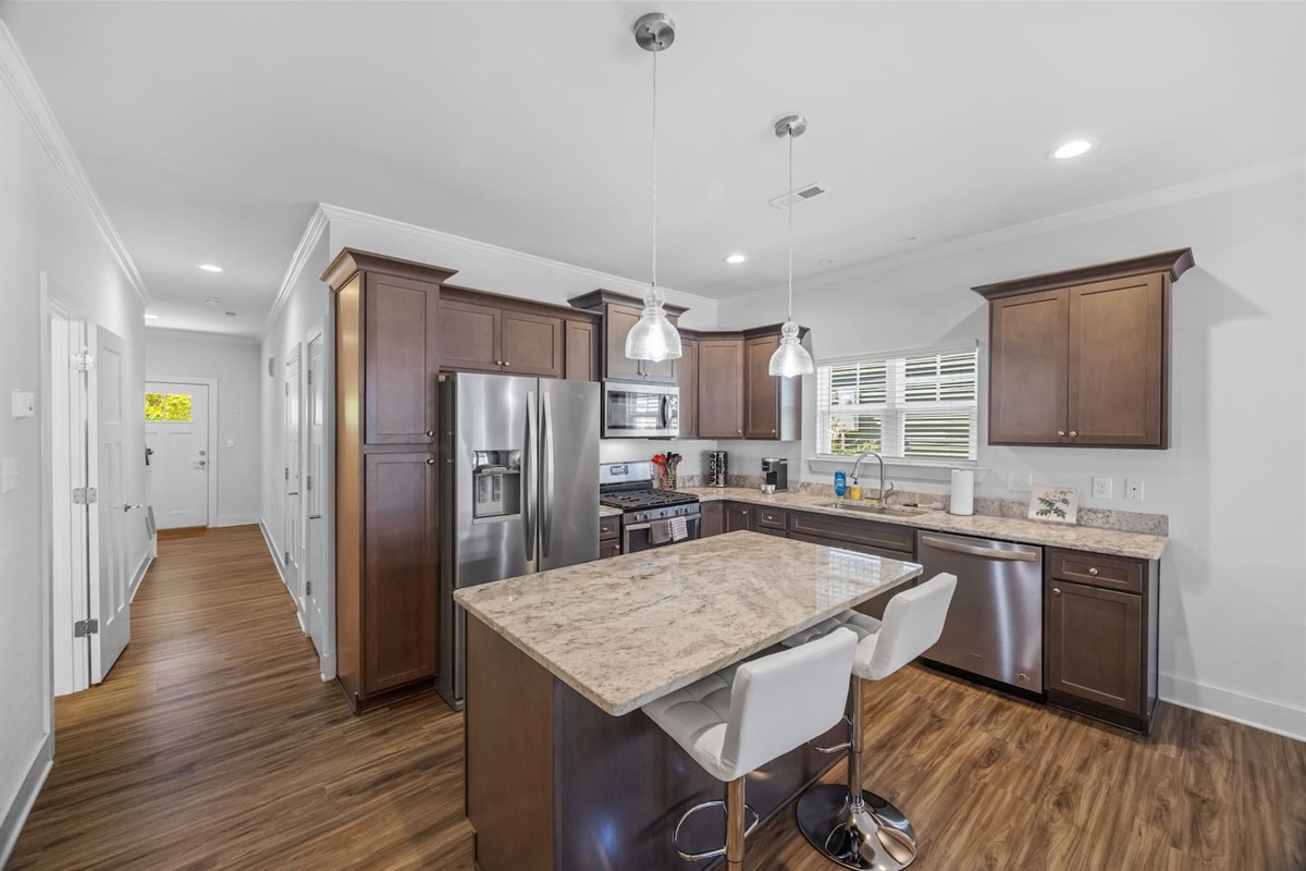 Large windows bring in natural light, highlighting warm wood cabinetry and sleek finishes.