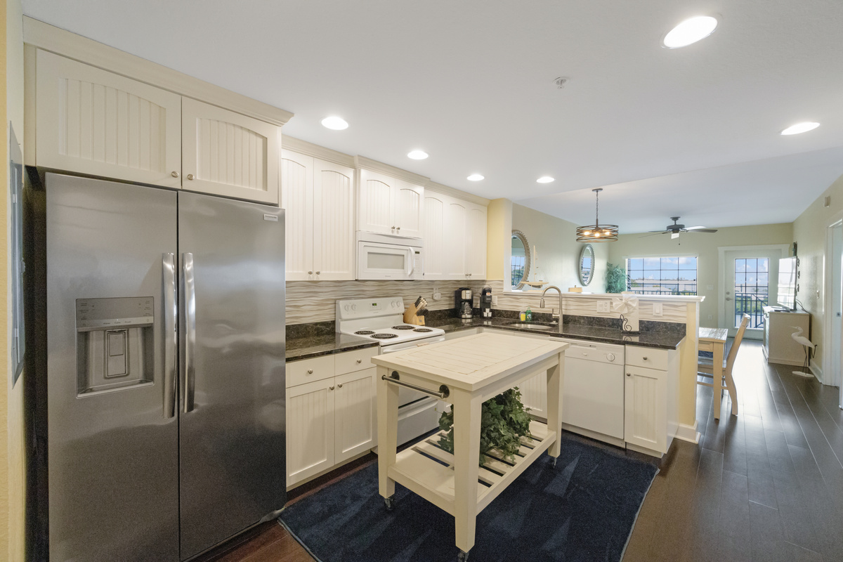 Kitchen - fully equipped w/ a microwave, dishwasher, full size fridge, Mr. Coffee, range, stackable washer/dryer, pots/pans, dishes and silverware.