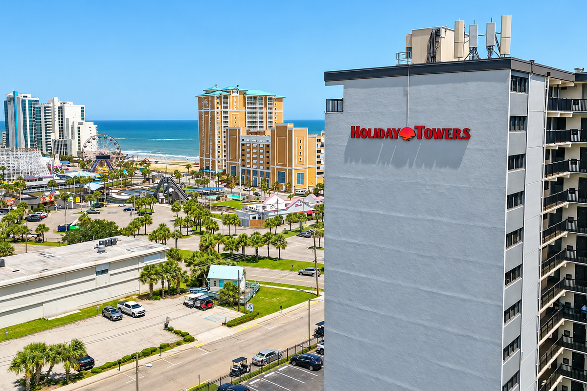 Holiday Towers exterior with ocean views nearby and Myrtle Beach attractions just across the way.