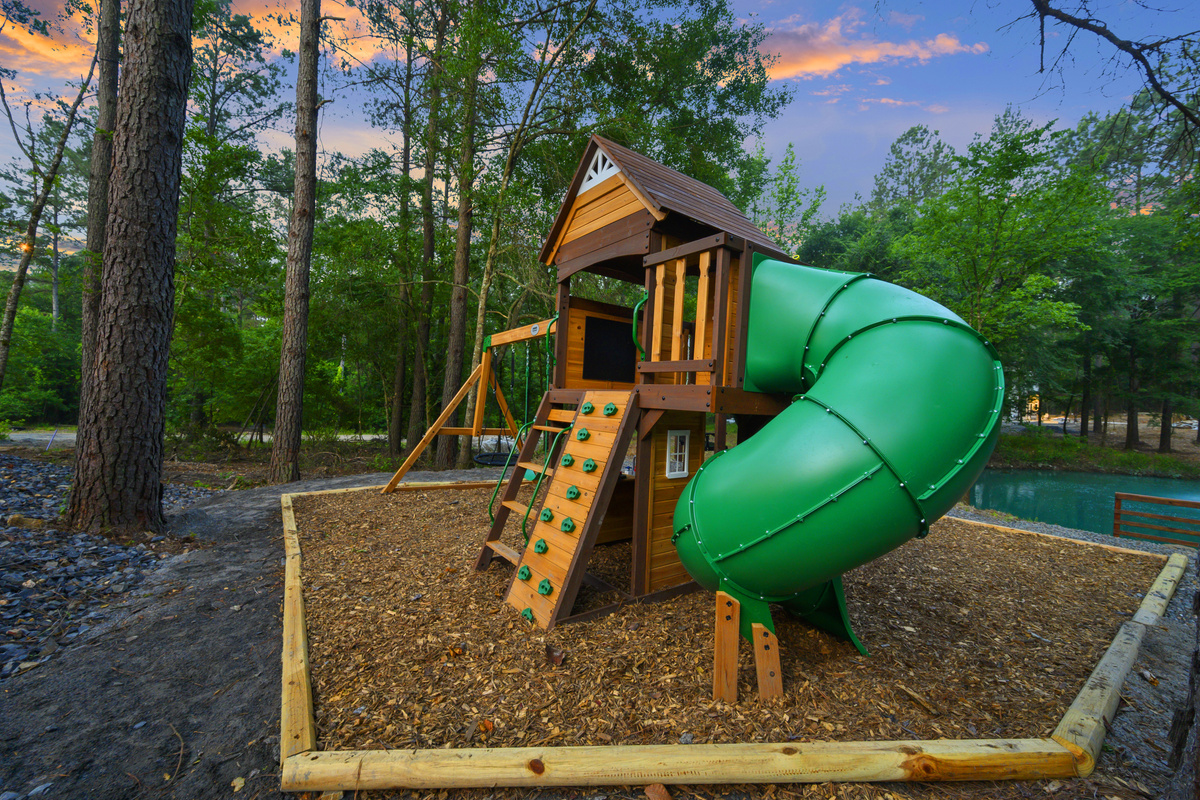 A playset built for little imaginations, where kids can climb, slide, swing & turn outdoor play into their own adventure, all tucked beneath the pines with the pond just beyond.
