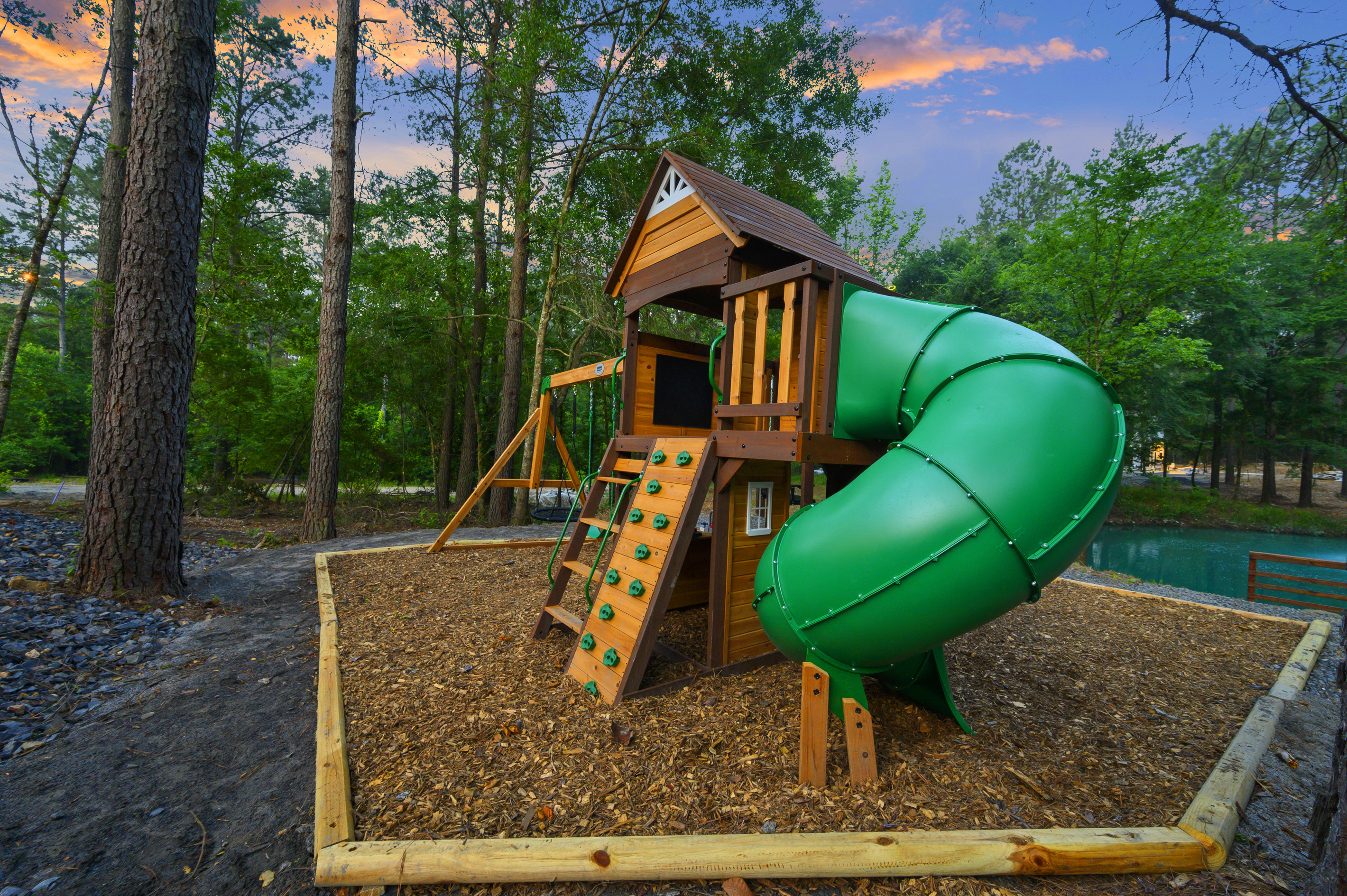 A playset built for little imaginations, where kids can climb, slide, swing & turn outdoor play into their own adventure, all tucked beneath the pines with the pond just beyond.
