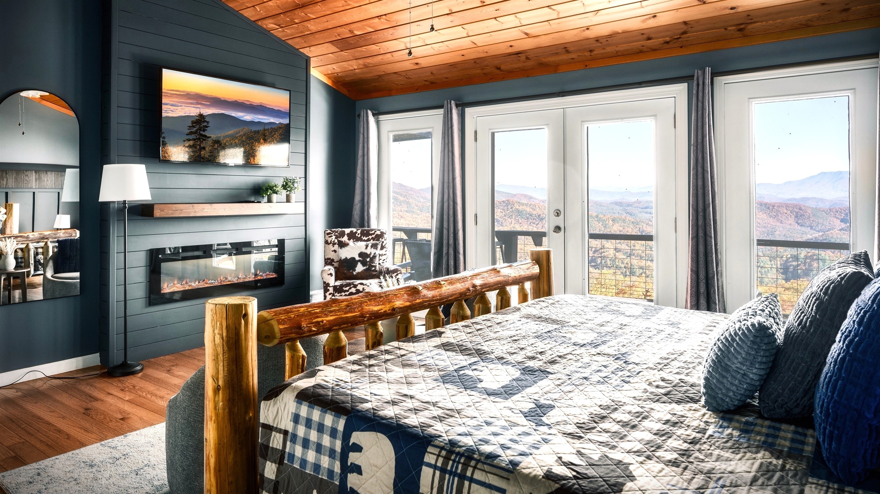 Enjoy that beautiful view right from your bed when you wake up every morning! This is the Master Bed on the main floor complete with electric fireplace combined with floor to ceiling glass door and window overlooking the AMAZING mountain view.