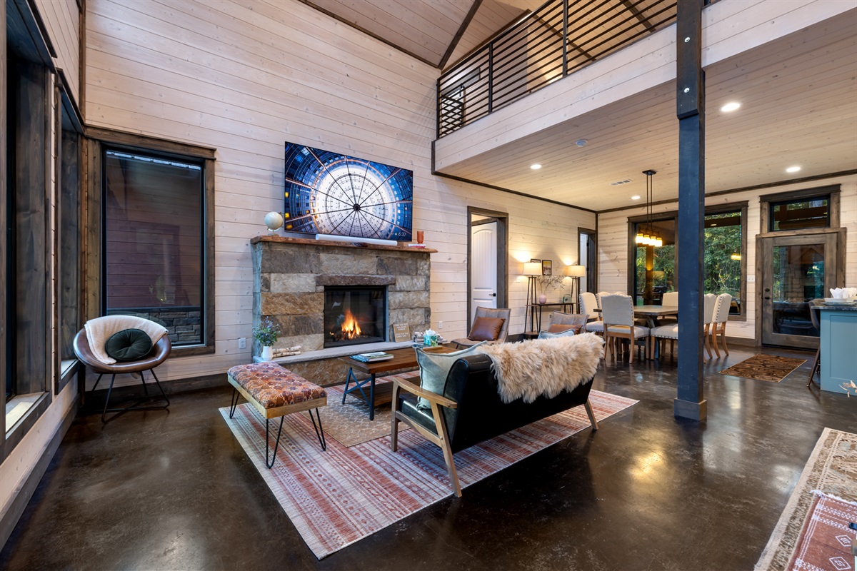 Cozy main living area featuring a comfortable sofa set positioned directly in front of the TV and indoor fireplace, creating the perfect spot for movie nights, relaxation, and gathering together in a warm, inviting setting.
