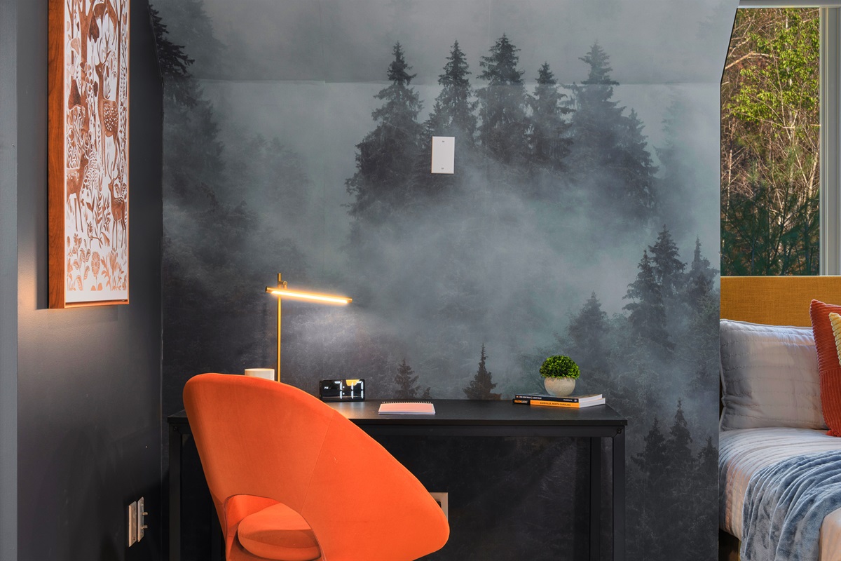 Design-forward bedroom with subtle mountain-inspired wall art - ties into the Asheville setting