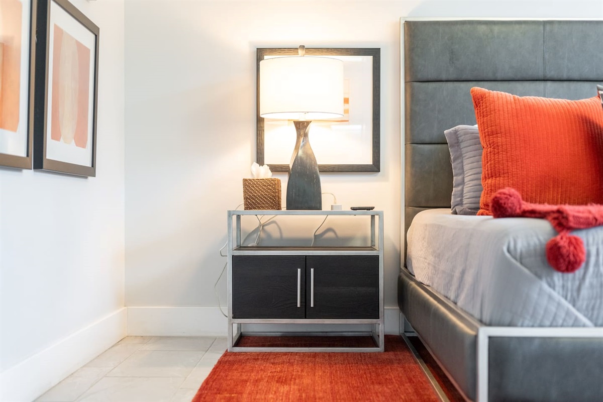 This sleek, modern nightstand is perfectly paired with a sculptural lamp and framed art, adding function and flair next to the king bed.

