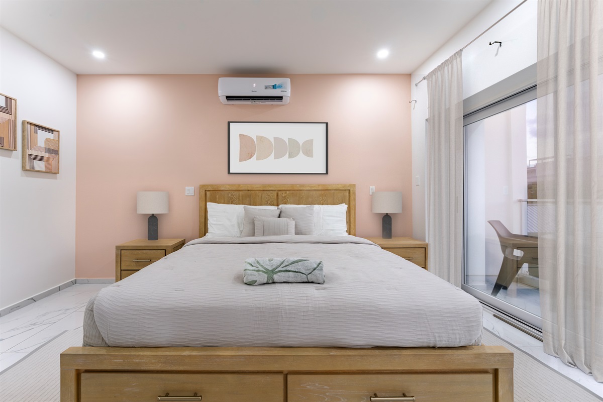 Close-up of the primary king bed with crisp linens and calming accent décor