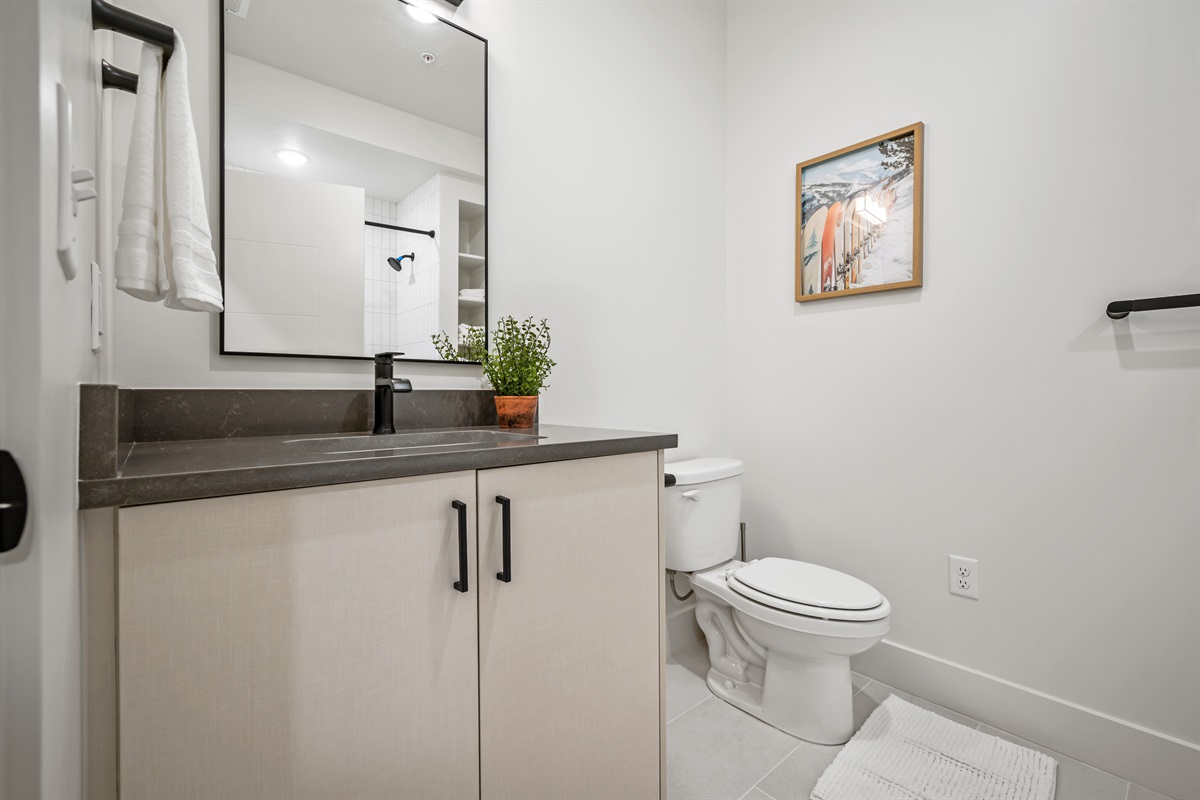 Enjoy sleek design with a spacious vanity, fresh greenery, and thoughtful touches.
