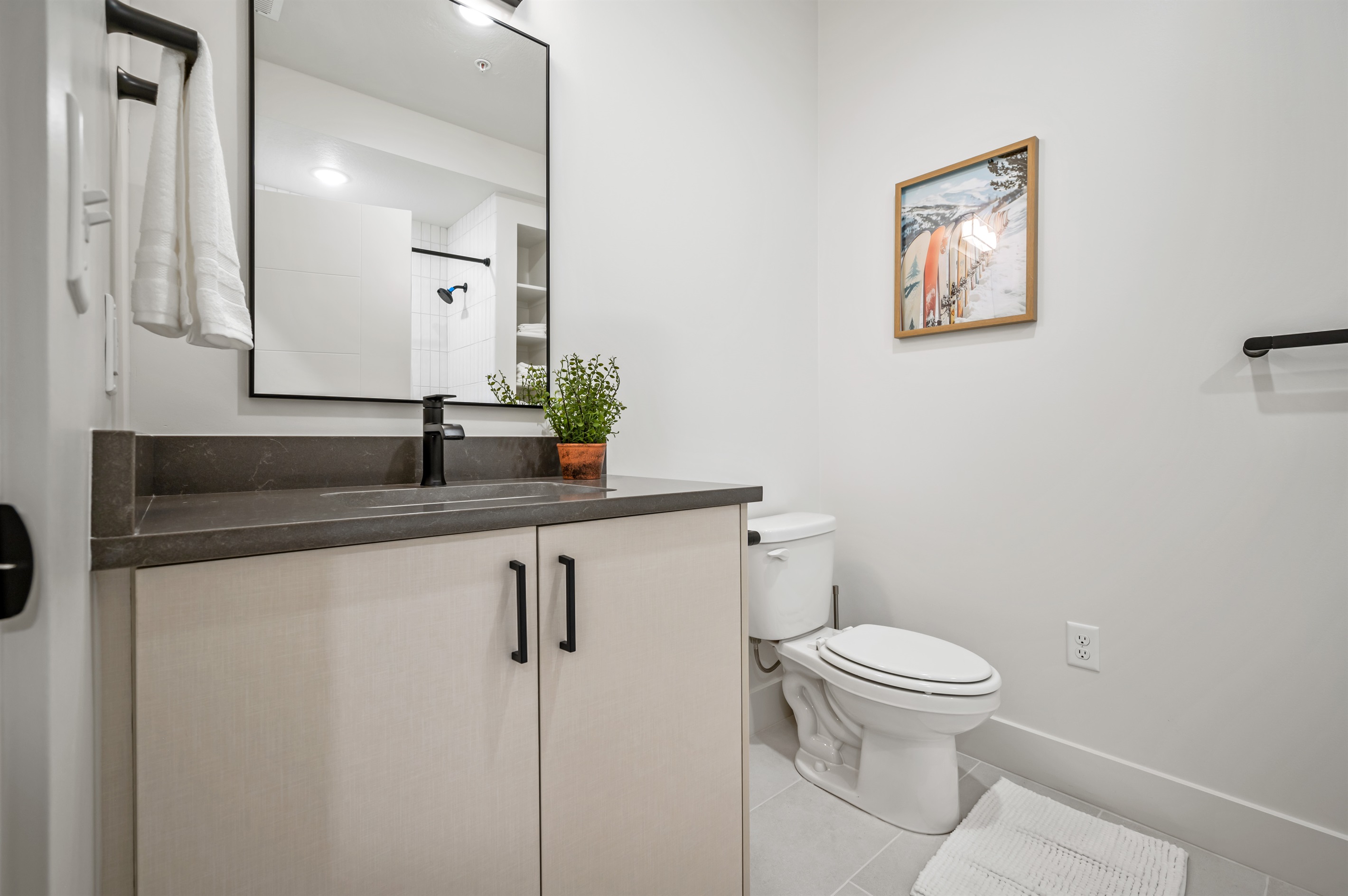 Enjoy sleek design with a spacious vanity, fresh greenery, and thoughtful touches.
