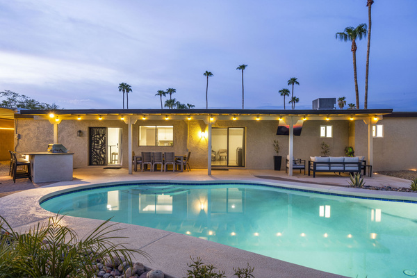 Private pool surrounded by palm trees and outdoor seating