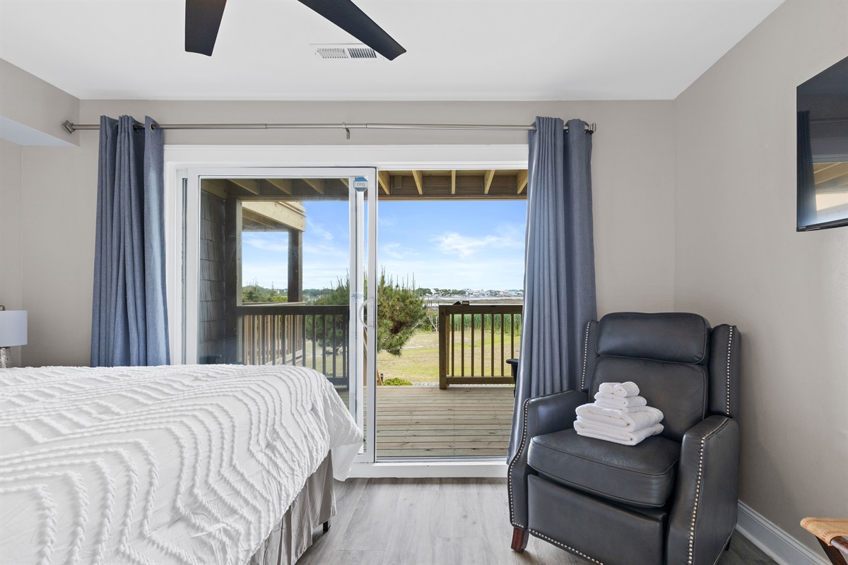 Sliding glass doors open to a private deck overlooking the marsh