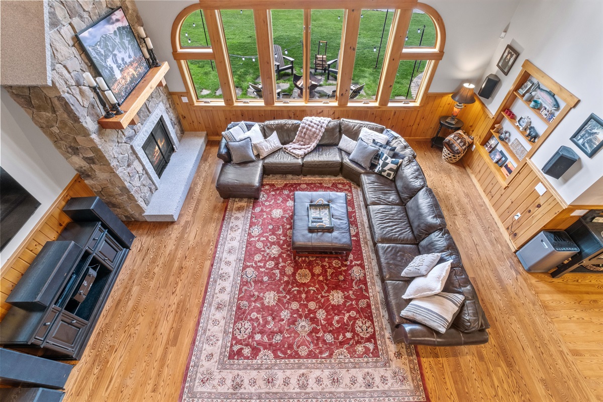 Living room with massive couch, 85" tv, sound system, pool table, and bubble hockey game
