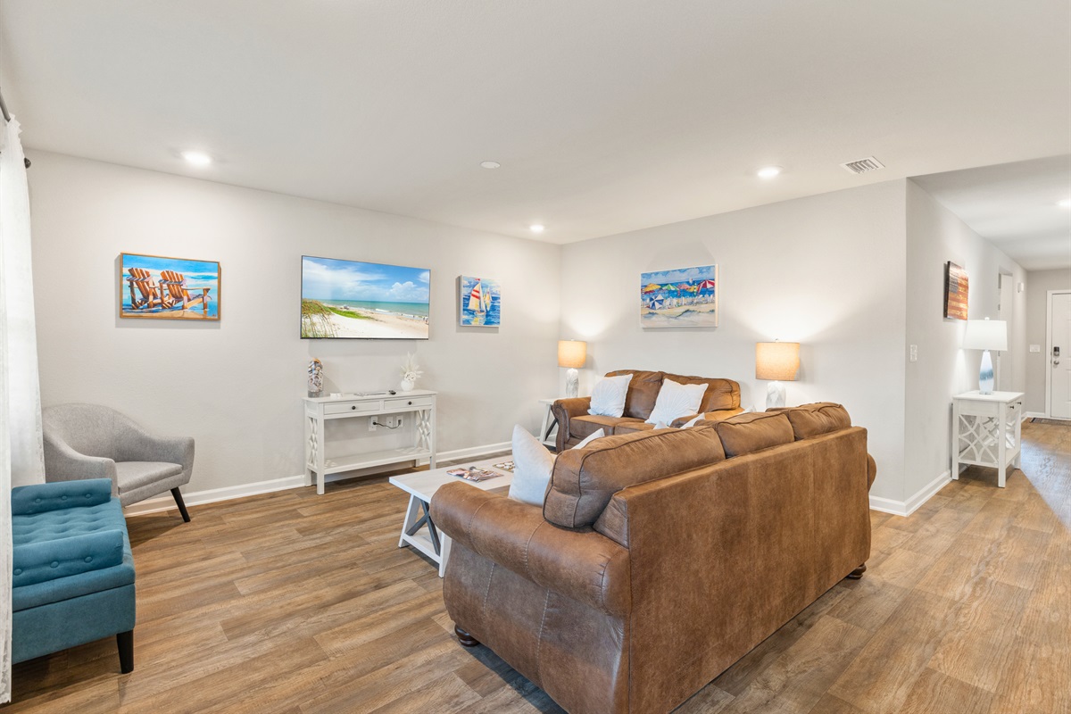 Open, airy living room with natural light and soft beach tones for ultimate relaxation.