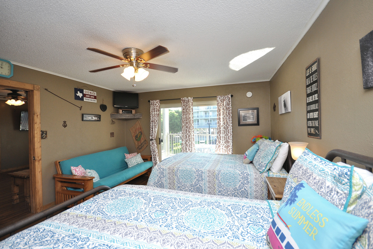Primary bedroom with two full size beds and seating area.