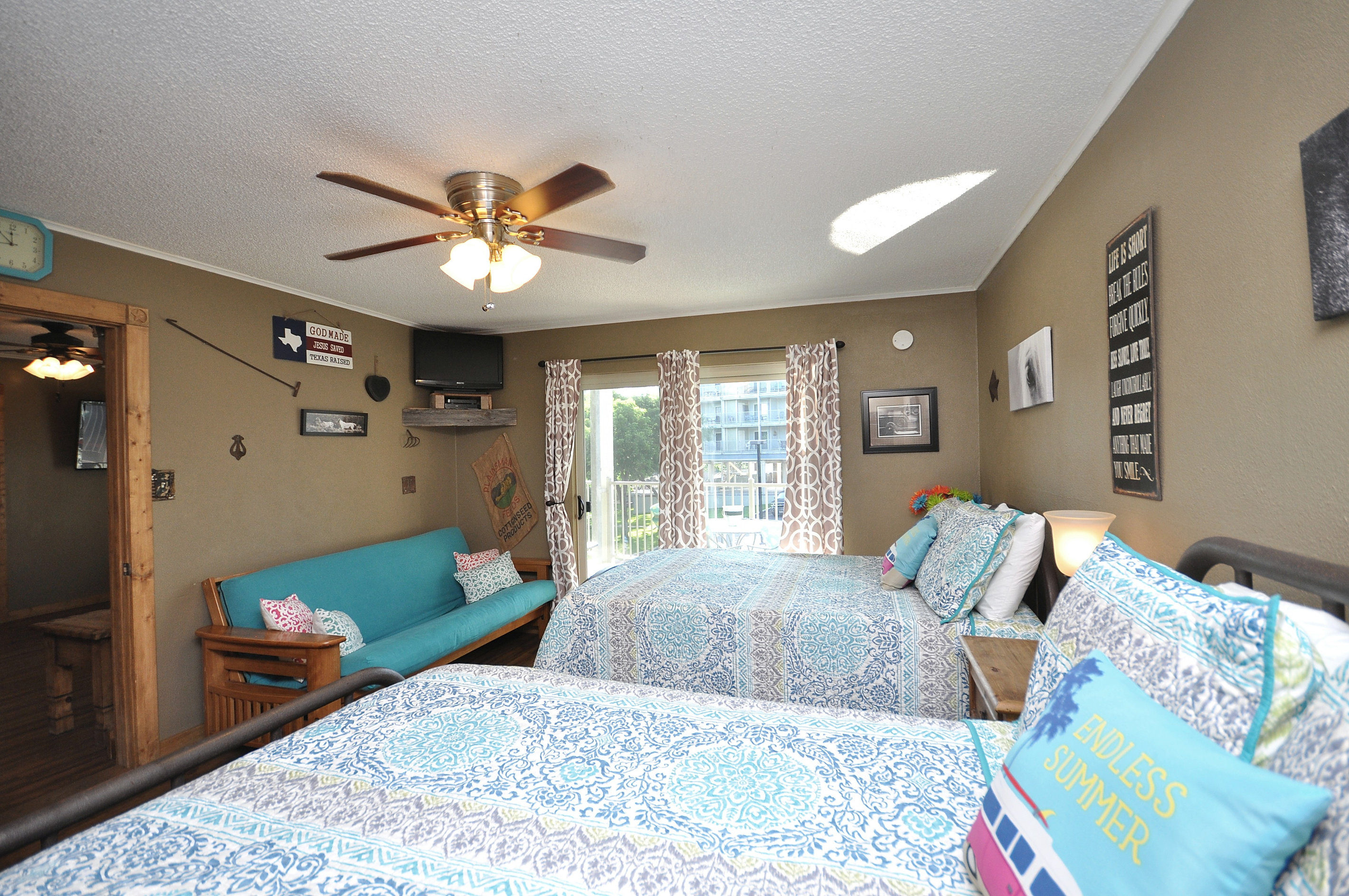 Primary bedroom with two full size beds and seating area.