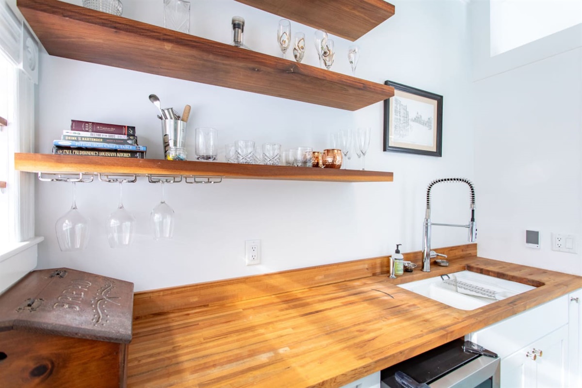 A sleek kitchenette sink, perfectly integrated into the counter with modern fixtures, providing a practical space for washing dishes or preparing food in a compact kitchen.