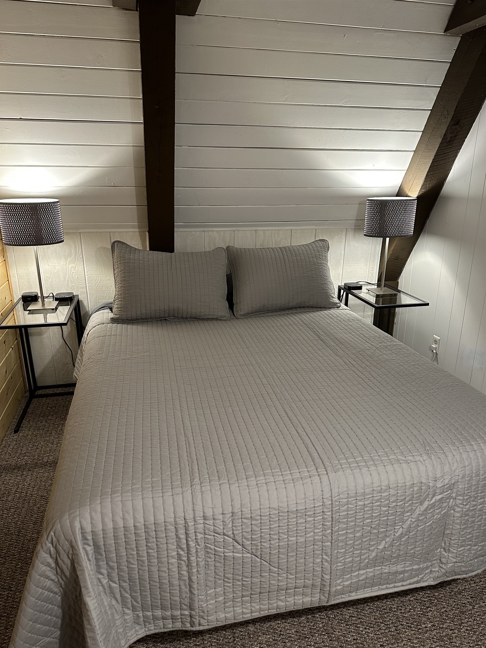 The 1st Floor back bedroom has a wonderful queen bed with new mattress that you'll fall into after a day exploring the U.P.  No worries about finding places to plug in your devices - a charging block is available on each nightstand.