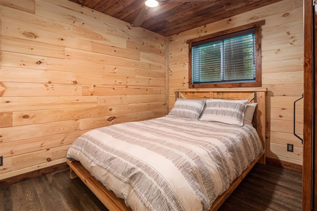 Comfortable bedroom with warm wood-paneled walls