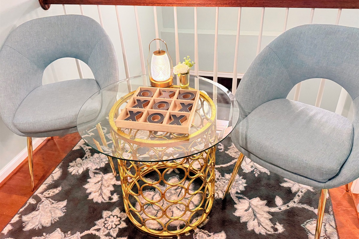 Conversation-ready lounge nook with modern chairs, accent rug, and warm gold decor. 