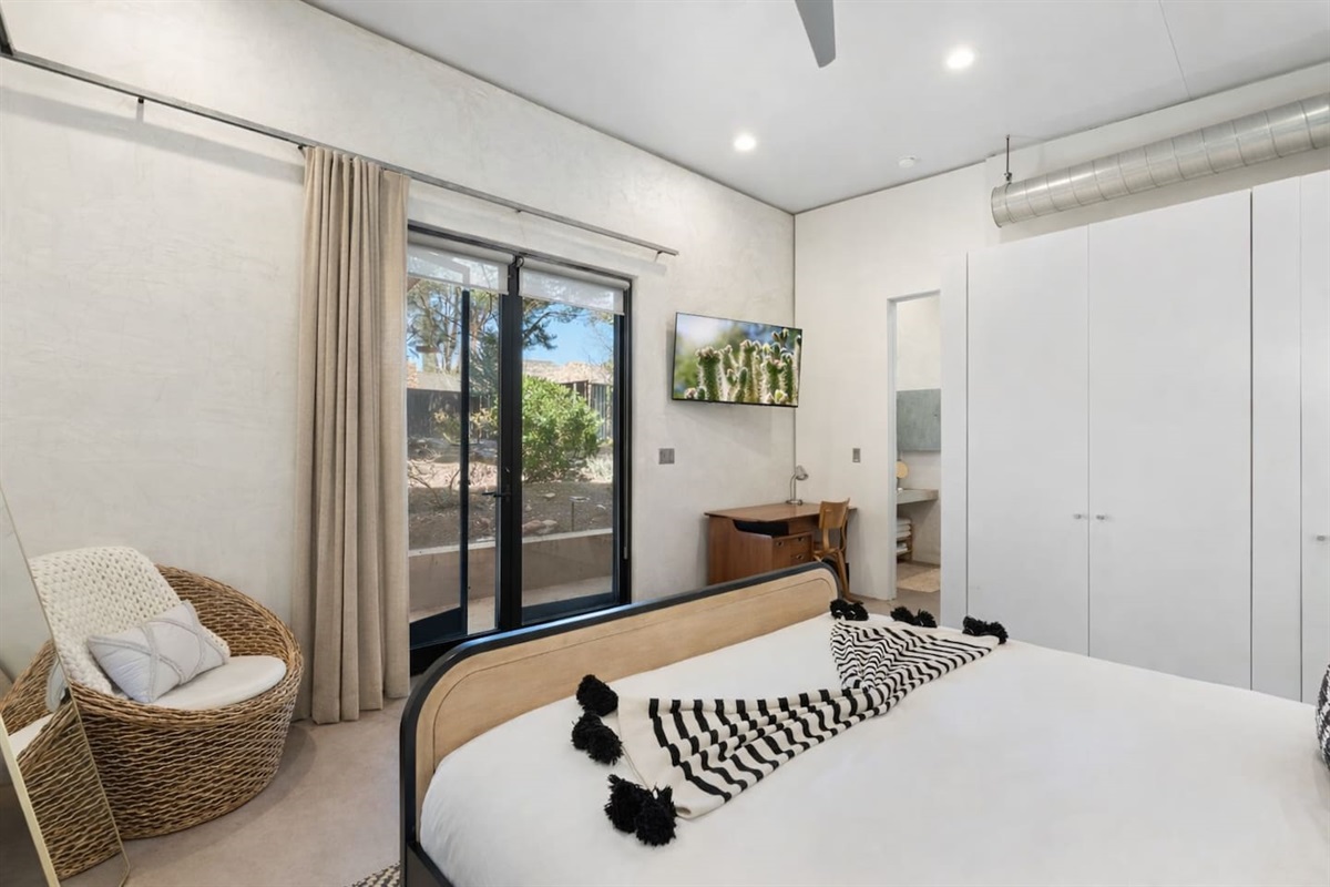 Bright bedroom with modern finishes, workspace nook, and private outdoor access.