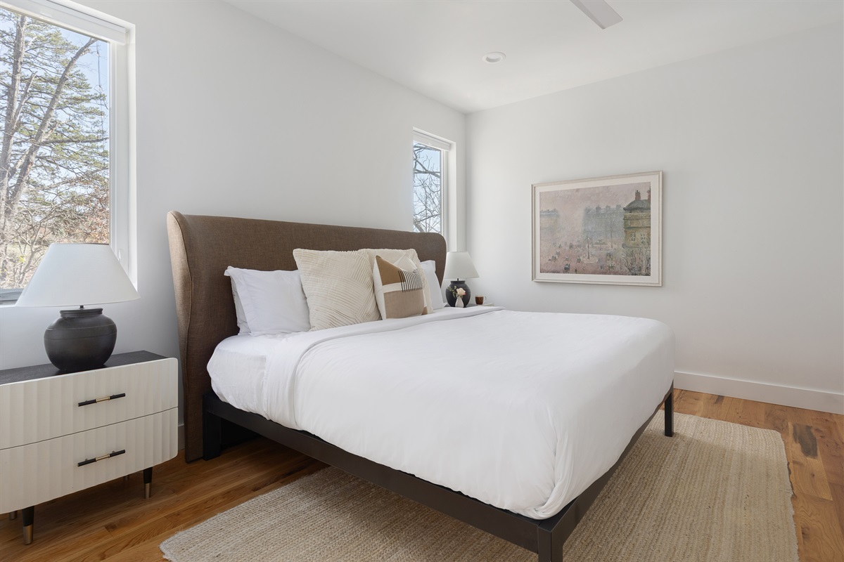 {Primary Bedroom} A bright, modern retreat + ensuite bath with soft textures, serene artwork, and forest-lined views—your calm landing spot at Gallery House.