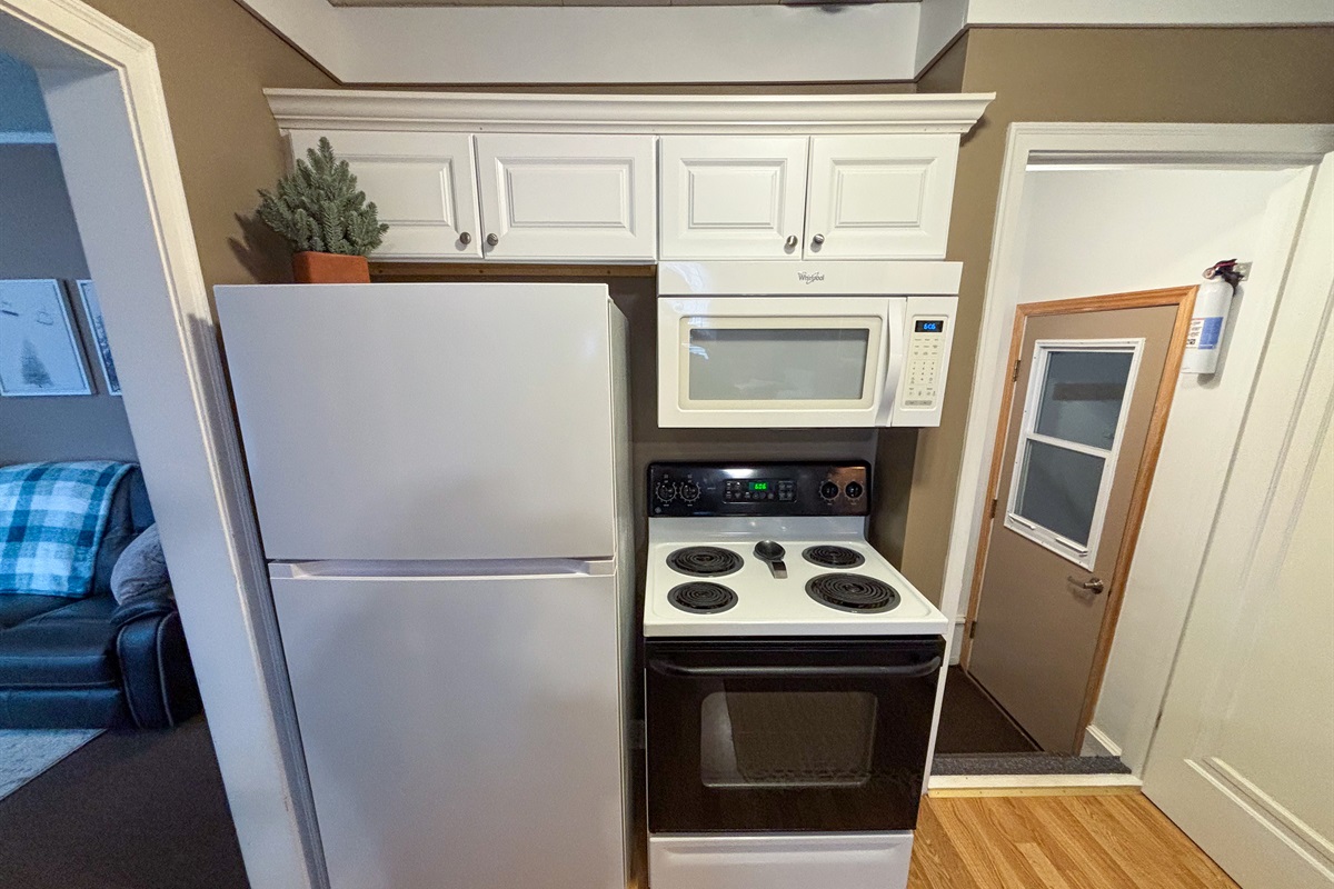 Modern and efficient—everything you need to create a delicious meal. The kitchen features a stainless steel refrigerator, stove, coffee maker, kitchenette oven, kettle, and blender